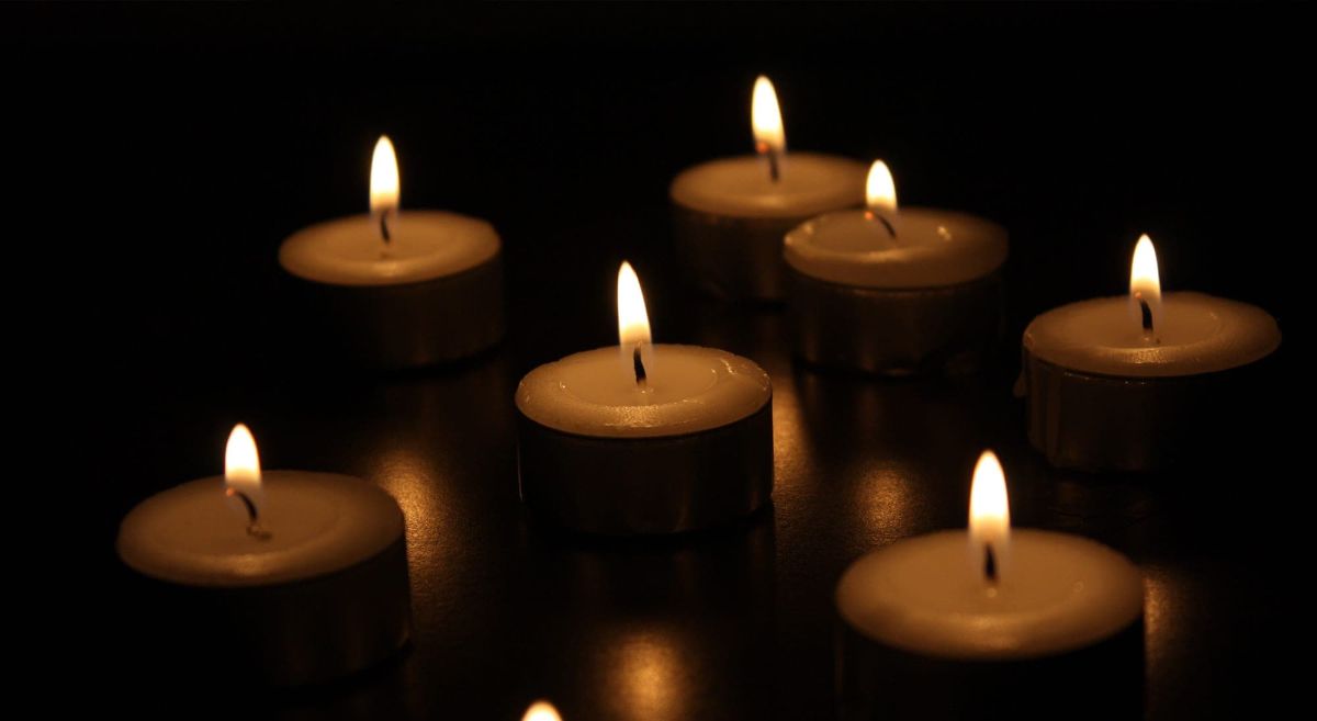 display of seven candles alight with dark background